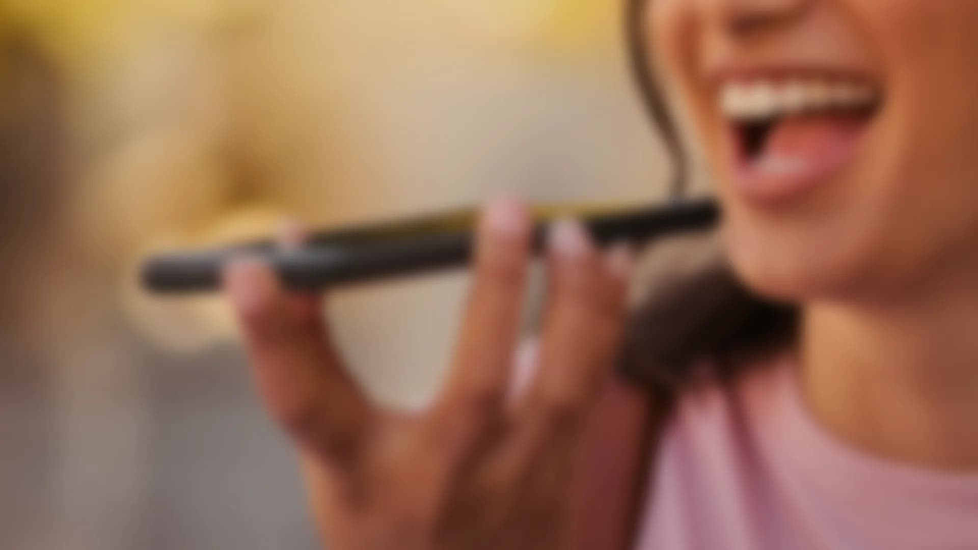 A woman speaking into a phone held flat, out of focus